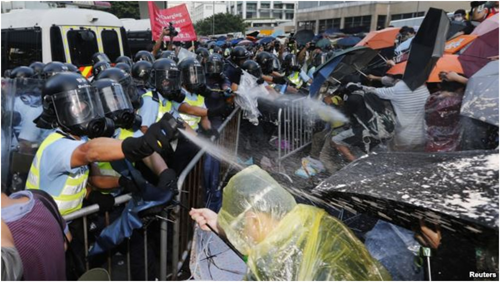 Cảnh sát chống bạo động xịt hơi cay trong lúc đụng độ với người biểu tình chặn con đường chính bên ngoài trụ sở chính quyền Hong Kong, ngày 28 tháng 9, 2014