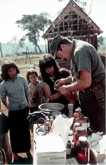 1966, Vietnam --- 1966-Vietnam- Hình ảnh cho thấy một y tá lực lượng hải quân Mỹ đang điều trị cho trẻ em trong làng --- Image by © Bettmann/CORBIS